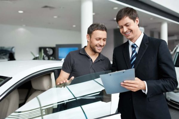 Young man with a salesman in a motor show